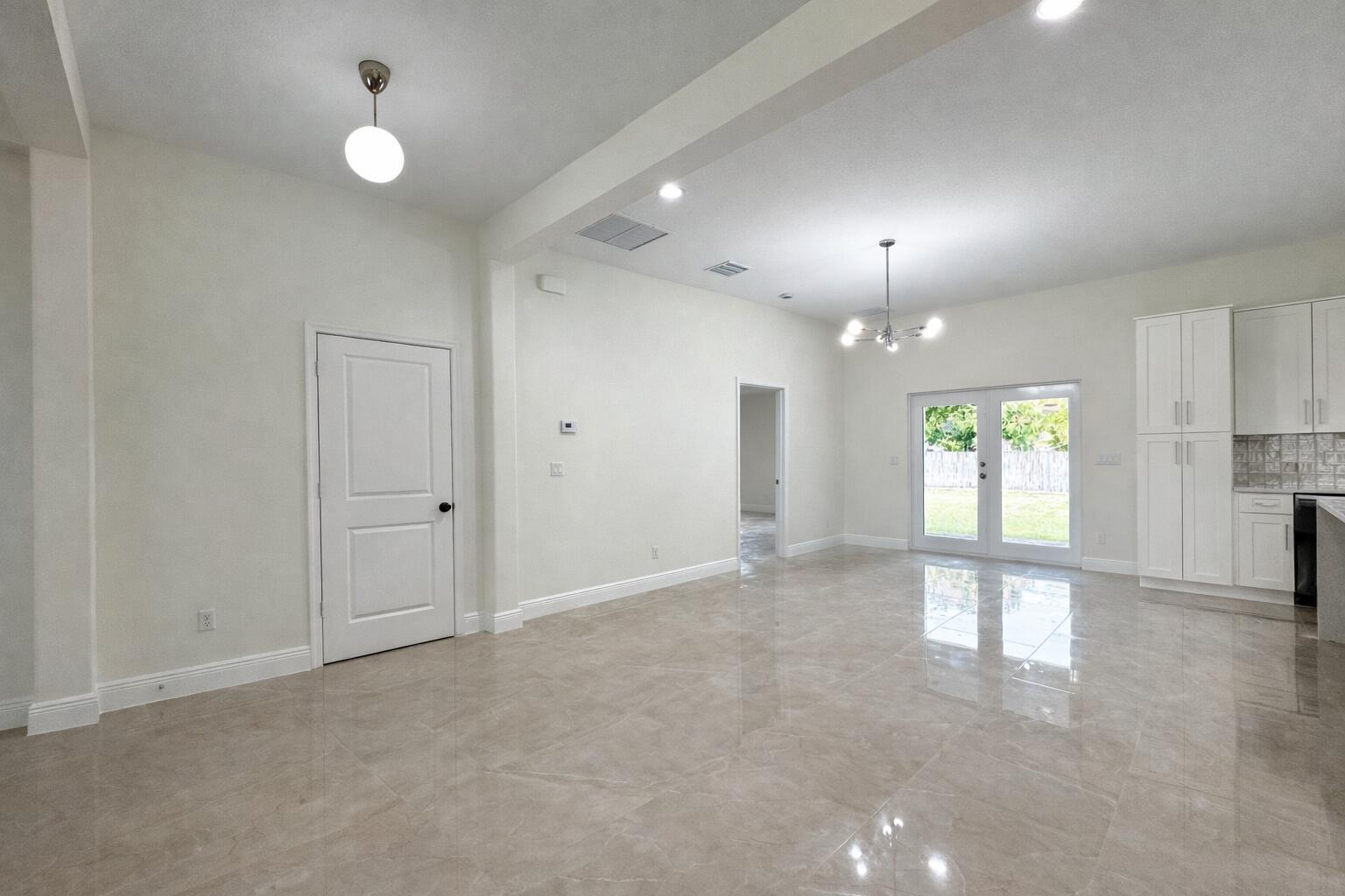 655 Southwest Seagull Terrace Port St. Lucie, FL 34953 - Photo 10 of 24 an empty room with windows and chandelier fan