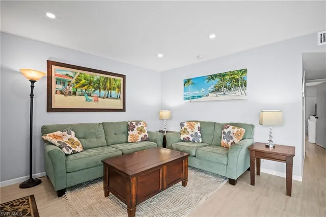 a living room with furniture and a painting on the wall