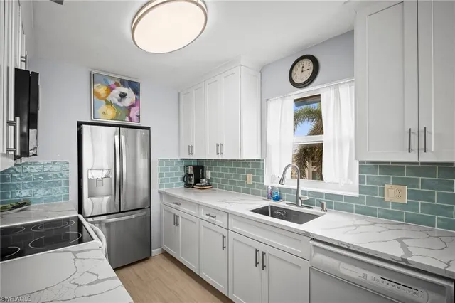 a kitchen with stainless steel appliances granite countertop a refrigerator and a sink