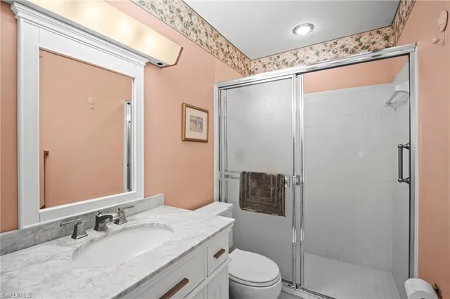 a bathroom with a granite countertop sink toilet and shower