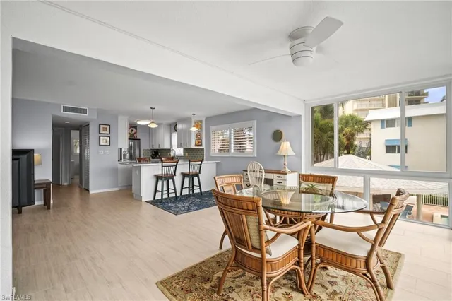 a dining room with furniture and a floor to ceiling window