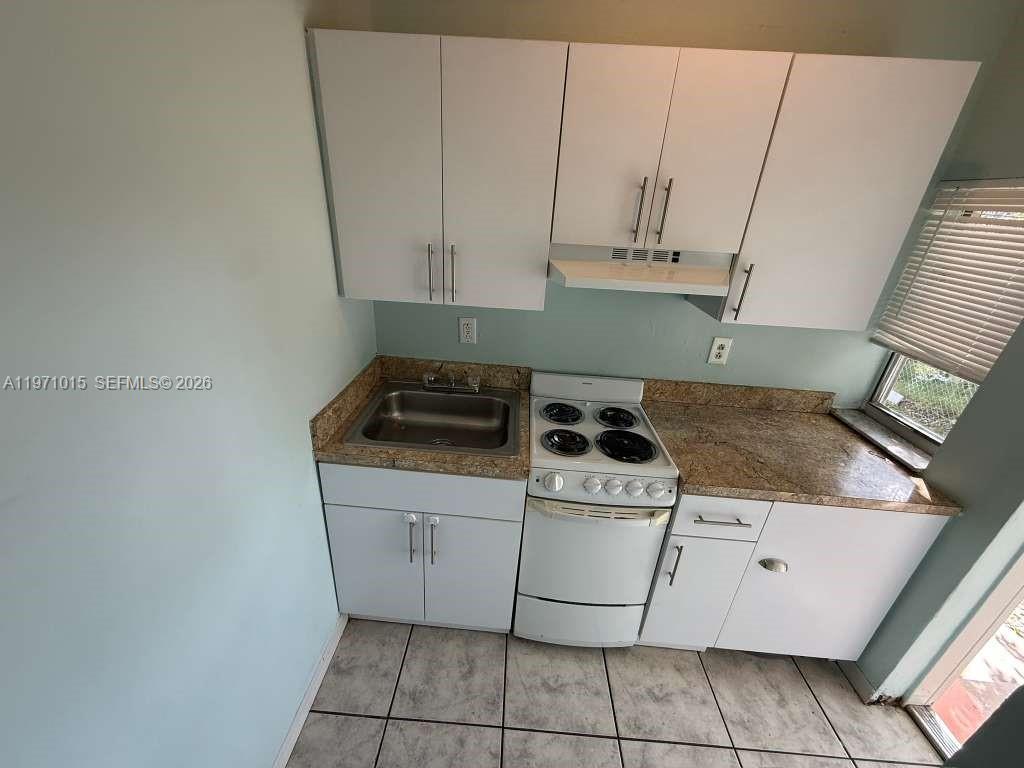 1751 Northwest 29th Street, Unit H Miami, FL 33142 - Photo 4 of 7 a stove top oven sitting inside of a kitchen