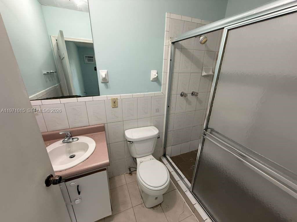 1751 Northwest 29th Street, Unit H Miami, FL 33142 - Photo 6 of 7 a bathroom with a sink a toilet and shower