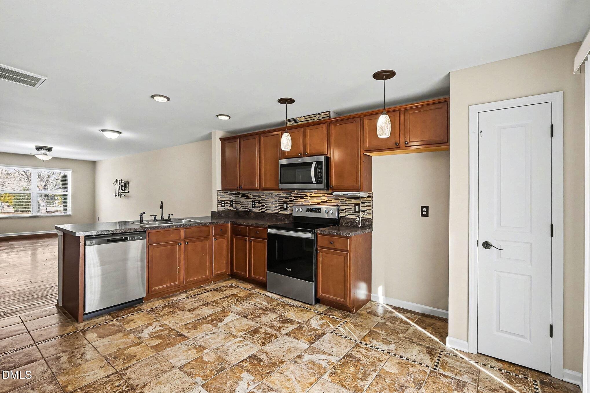 2905 Berkeley Springs Place Raleigh, NC 27616 - Photo 9 of 20 a kitchen with stainless steel appliances granite countertop a stove a sink and a refrigerator