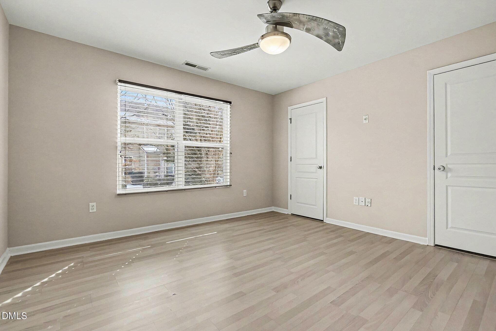 2905 Berkeley Springs Place Raleigh, NC 27616 - Photo 13 of 20 a view of an empty room with wooden floor and a window