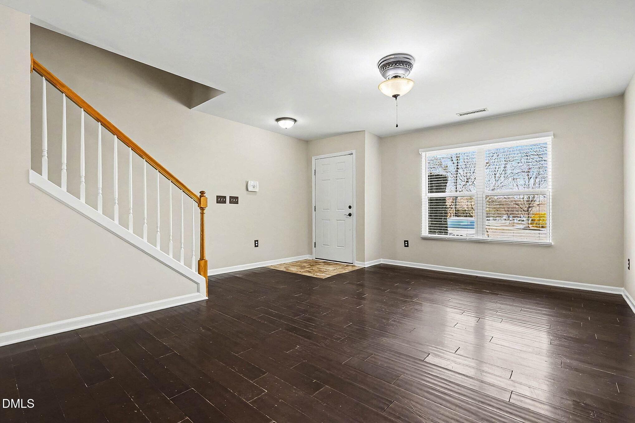 2905 Berkeley Springs Place Raleigh, NC 27616 - Photo 3 of 20 a view of an empty room with wooden floor and a window