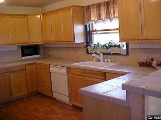 21361 Crestview Road Reno, NV 89521 - Photo 5 of 8 a kitchen with stainless steel appliances granite countertop a sink a stove cabinets and a potted plant