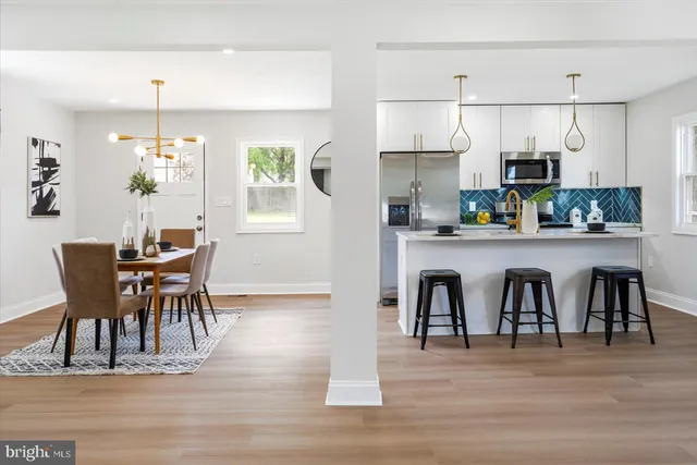 a dining room filled chandelier and wooden floor