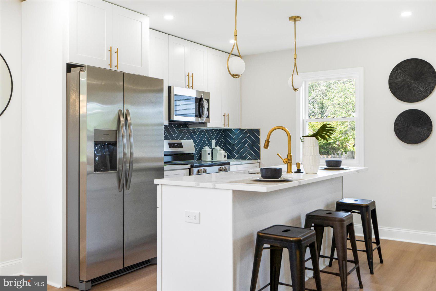 4810 Whitfield Chapel Road Lanham, MD 20706 - Photo 17 of 52 a kitchen with kitchen island white cabinets and stainless steel appliances