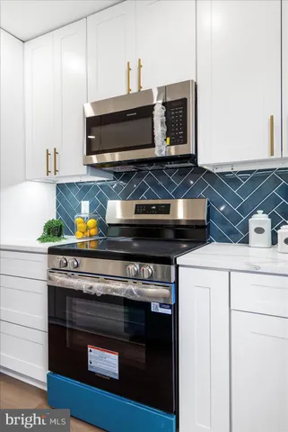 a stove top oven sitting inside of a kitchen