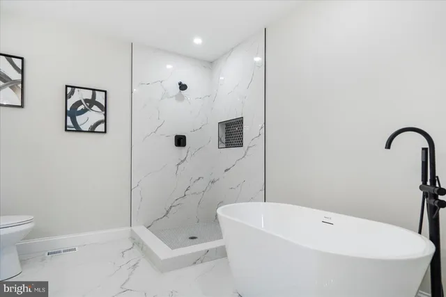 a bathroom with a white bath tub a toilet and a sink