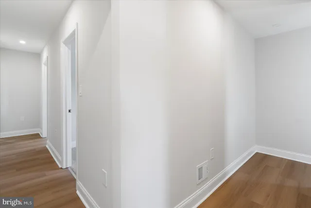 a view of a hallway with wooden floor