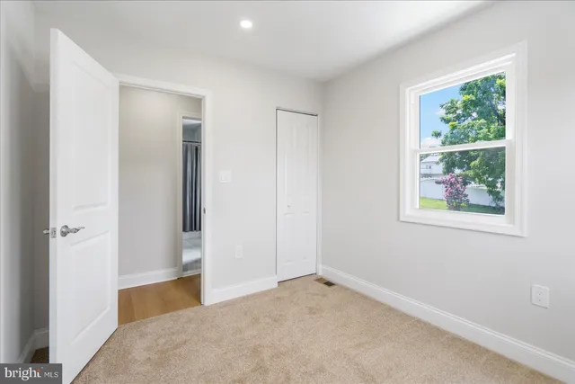 an empty room with windows and closet