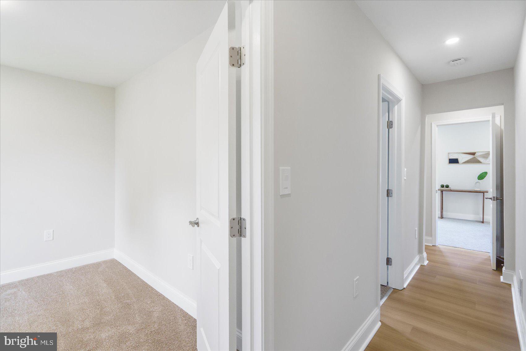 4810 Whitfield Chapel Road Lanham, MD 20706 - Photo 33 of 52 a view of a hallway with wooden floor and a bathroom