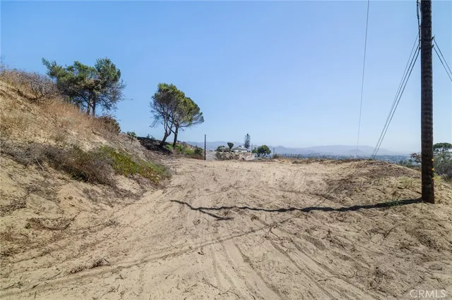 a view of a dry yard with wooden fence
