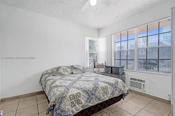 a bedroom with a bed and a large window