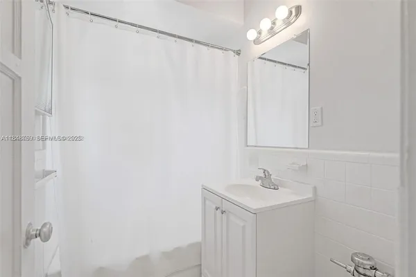 a bathroom with a sink a mirror and a shower curtain
