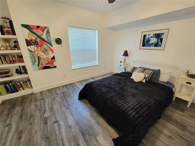a bedroom with bed and wooden floor