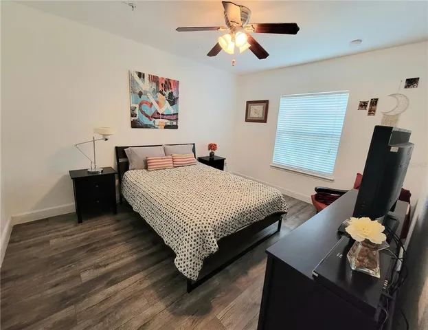 a bedroom with a bed and wooden floor