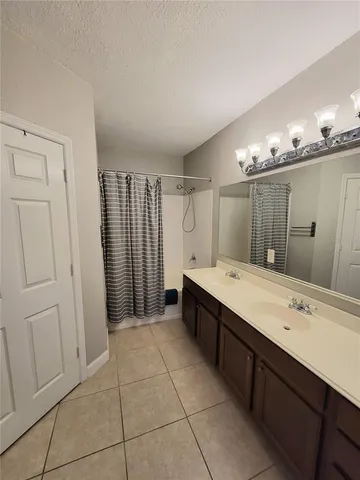 a bathroom with a double vanity sink a large mirror and a shower