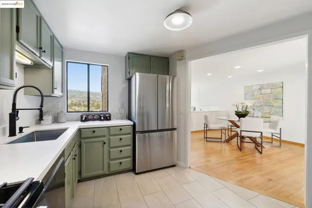 a kitchen with stainless steel appliances granite countertop a sink a stove and refrigerator