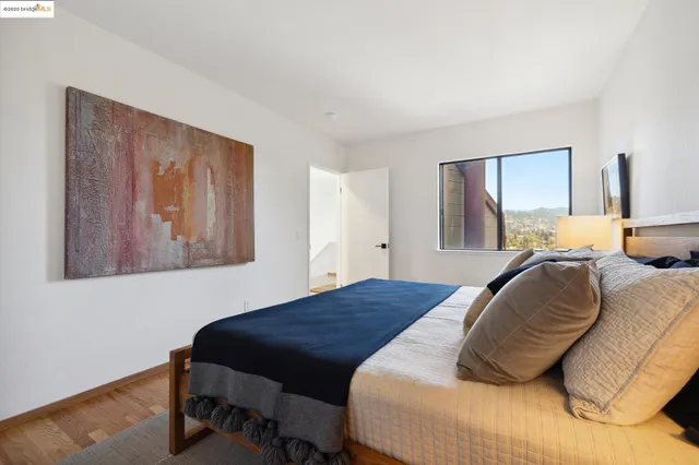 a bedroom with a bed and a painting on the wall