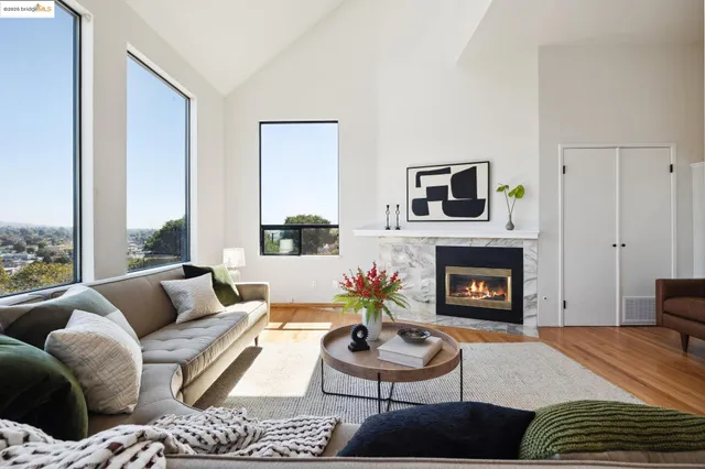 a living room with furniture a fireplace and a large window