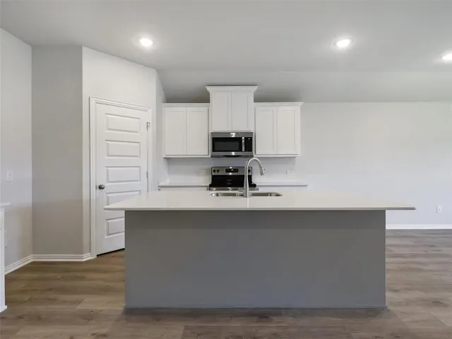 a kitchen with kitchen island a sink stainless steel appliances and cabinets
