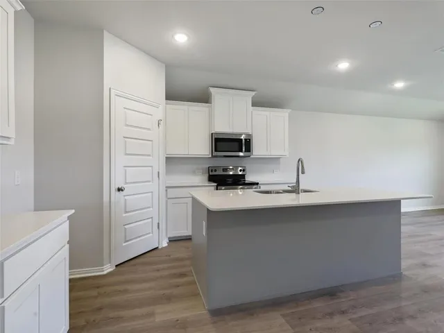a kitchen with stainless steel appliances a sink stove and cabinets