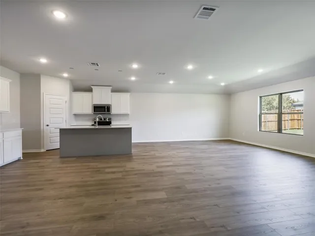 a view of kitchen with kitchen island microwave and stove top oven