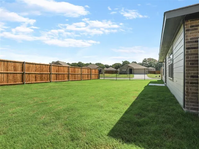 a view of a green field with wooden fence