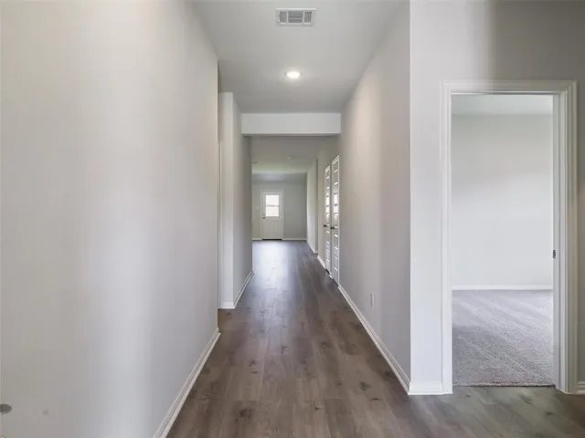 a view of a hallway with wooden floor