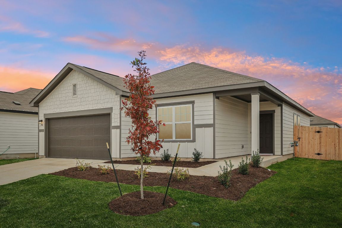 Ranch-style house with concrete driveway, a garage, and a gate