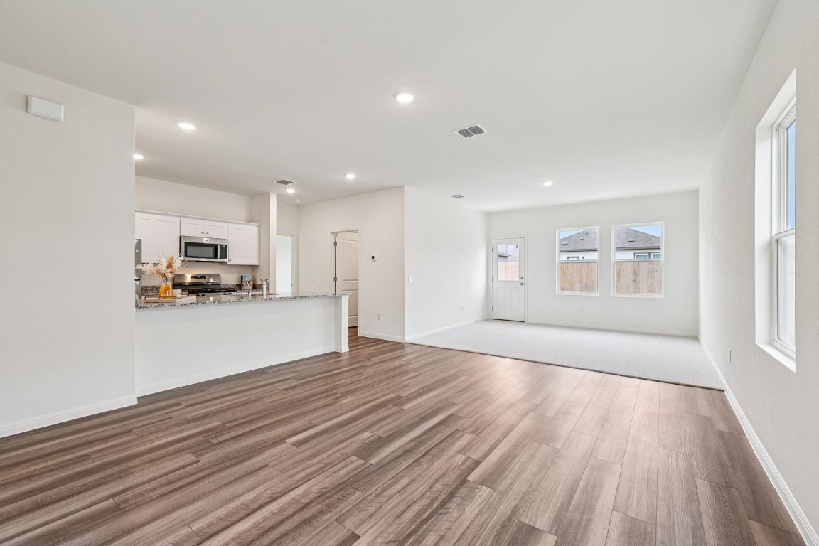 1516 Morris Loop San Marcos, TX 78666 - Photo 3 of 40 Unfurnished living room featuring dark wood-style floors and recessed lighting