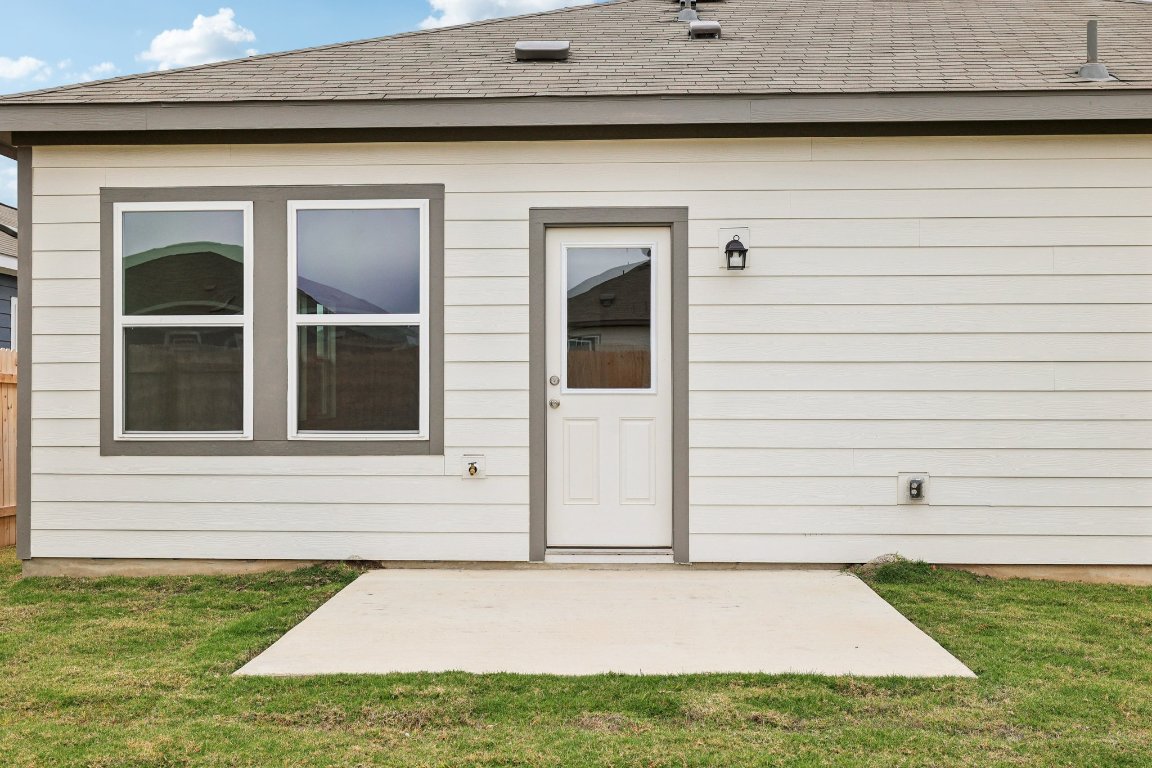1516 Morris Loop San Marcos, TX 78666 - Photo 37 of 40 View of exterior entry with a shingled roof, a yard, and a patio