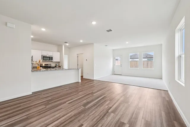 a kitchen with stainless steel appliances granite countertop a sink stove microwave and refrigerator
