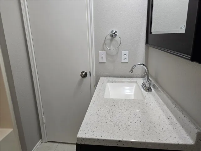 a bathroom with a granite countertop sink