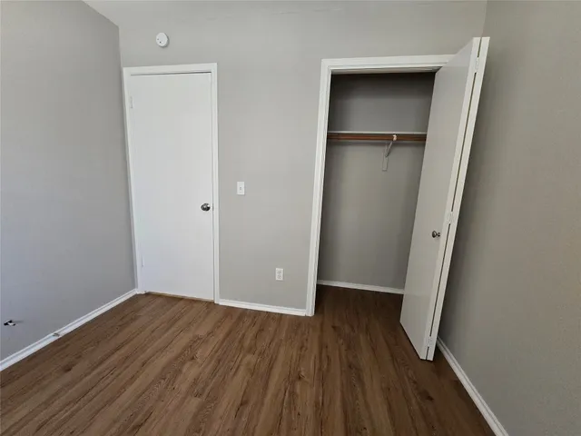 an empty room with wooden floor and closet
