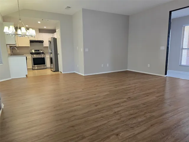 a view of kitchen with granite countertop cabinets and refrigerator
