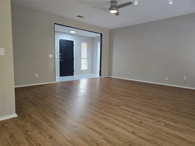 a view of an empty room with wooden floor