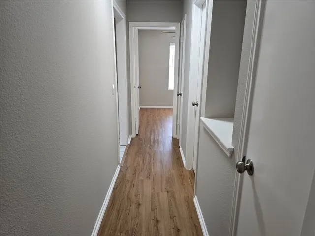 a view of a hallway with wooden floor