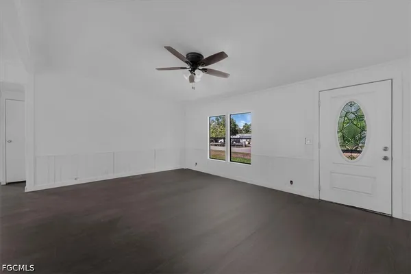 an empty room with windows and ceiling fan view