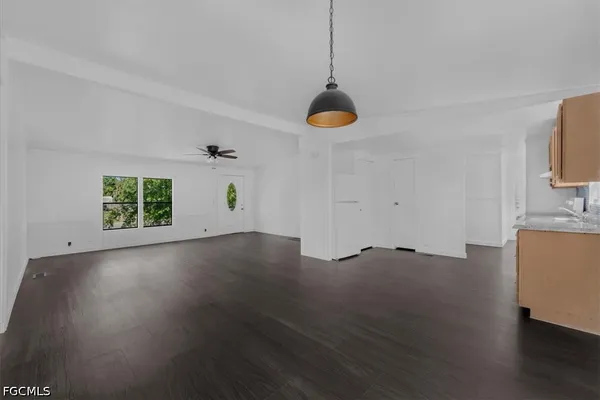 a view of empty room with wooden floor and window
