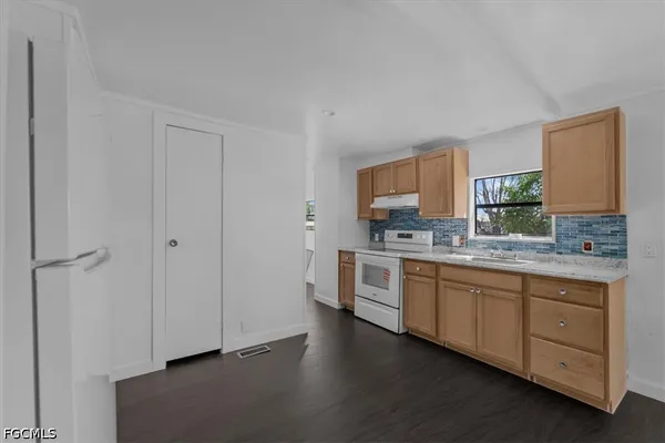 a kitchen with granite countertop white cabinets and white appliances