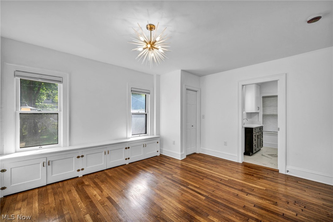 2135 Coventry Road, Unit DOWN Cleveland, OH 44118 - Photo 22 of 34 Unfurnished bedroom featuring dark wood-style floors, multiple windows, a chandelier, and ensuite bath