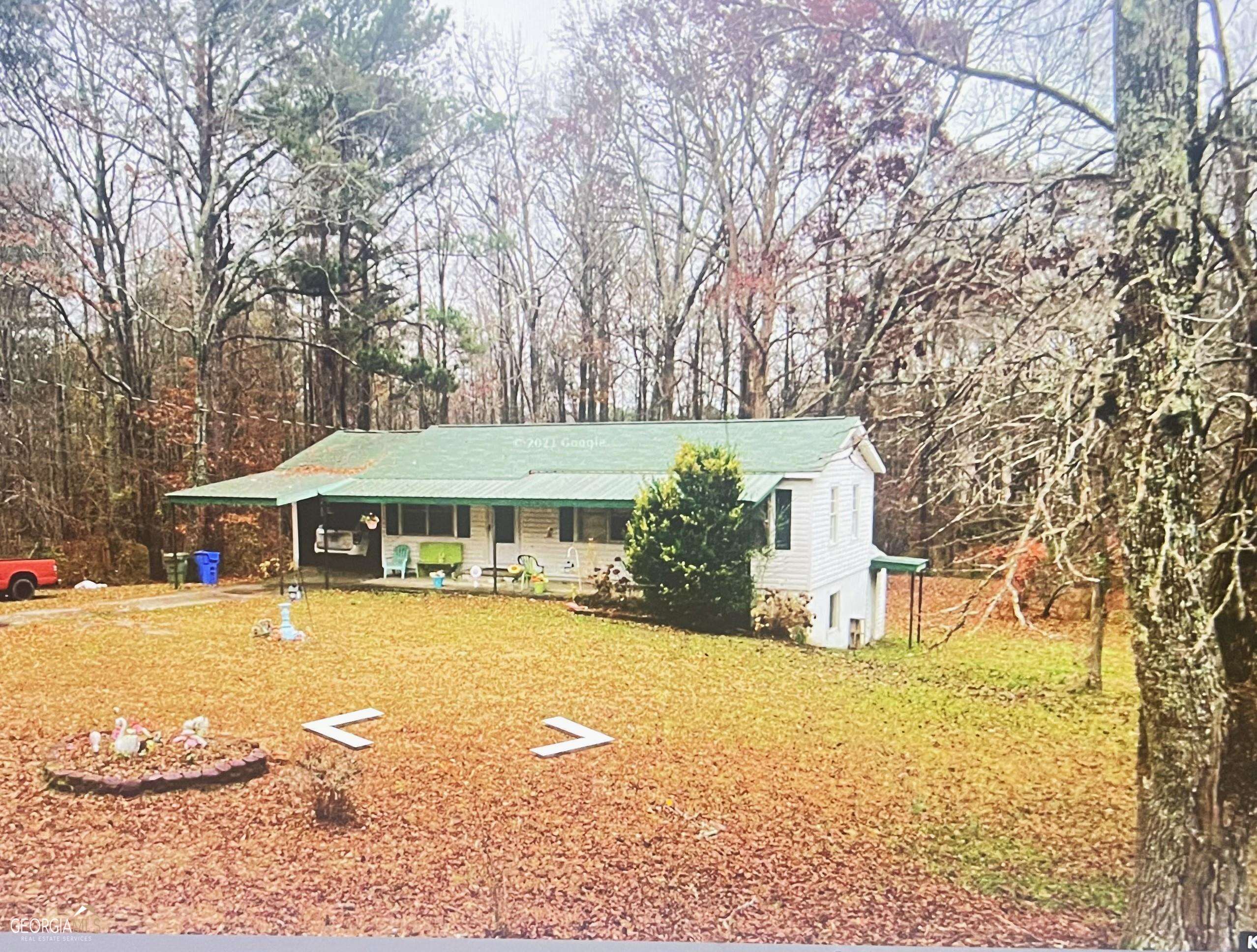 a front view of a house with a yard and trees