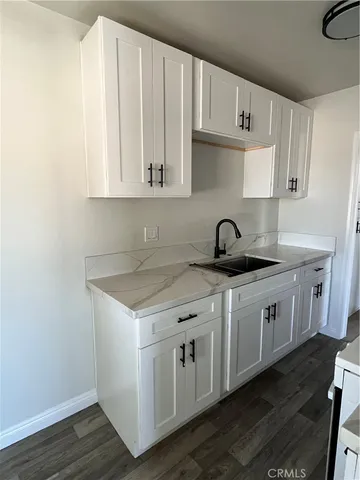 a kitchen with white cabinets and sink