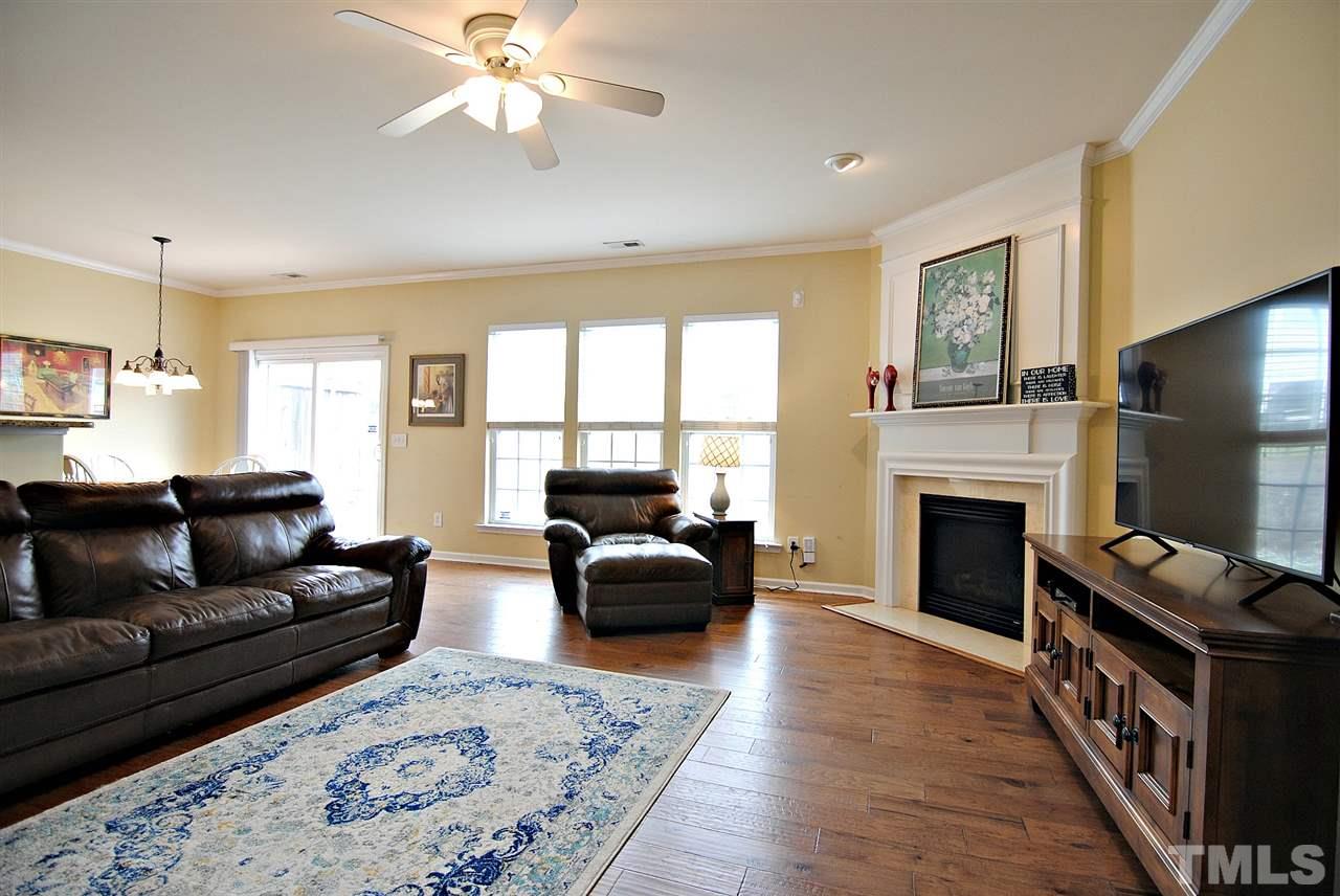 8220 Saltwood Place Raleigh, NC 27617 - Photo 4 of 15 a living room with furniture a fireplace and a flat screen tv