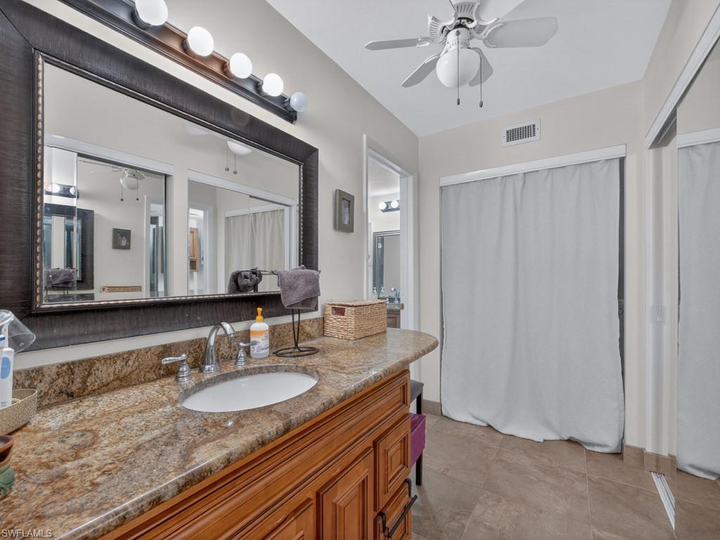 910 Vanderbilt Beach Road, Unit 317W Naples, FL 34108 - Photo 11 of 14 a bathroom with a granite countertop double vanity sink and a mirror