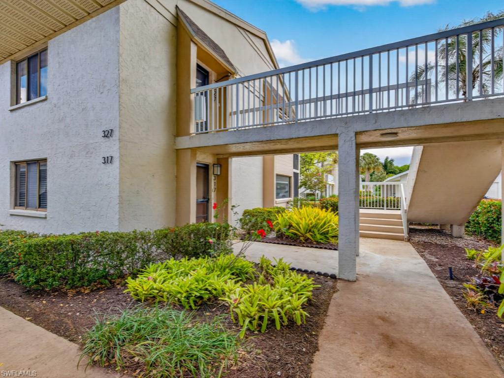 910 Vanderbilt Beach Road, Unit 317W Naples, FL 34108 - Photo 2 of 14 a view of a house with large windows and flower plants